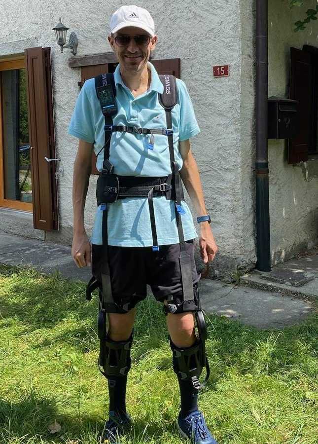 Roger Gassert in front of a house wearing a soft exoskeleton