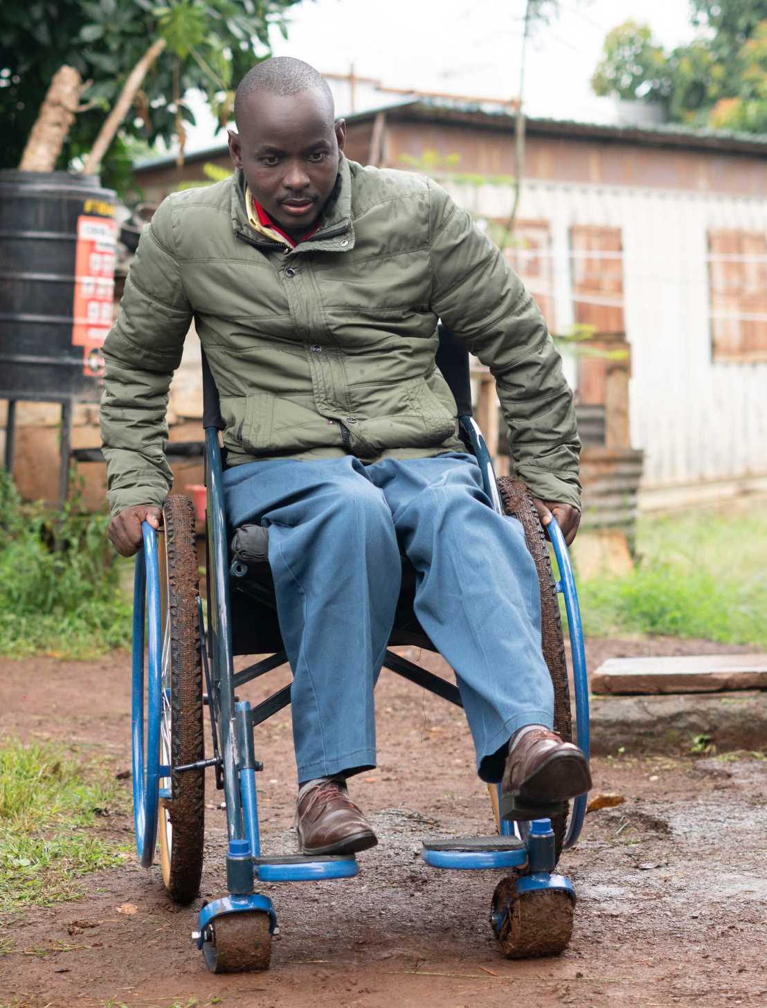 Enlarged view: man with wheelchair drives through muddy terrain
