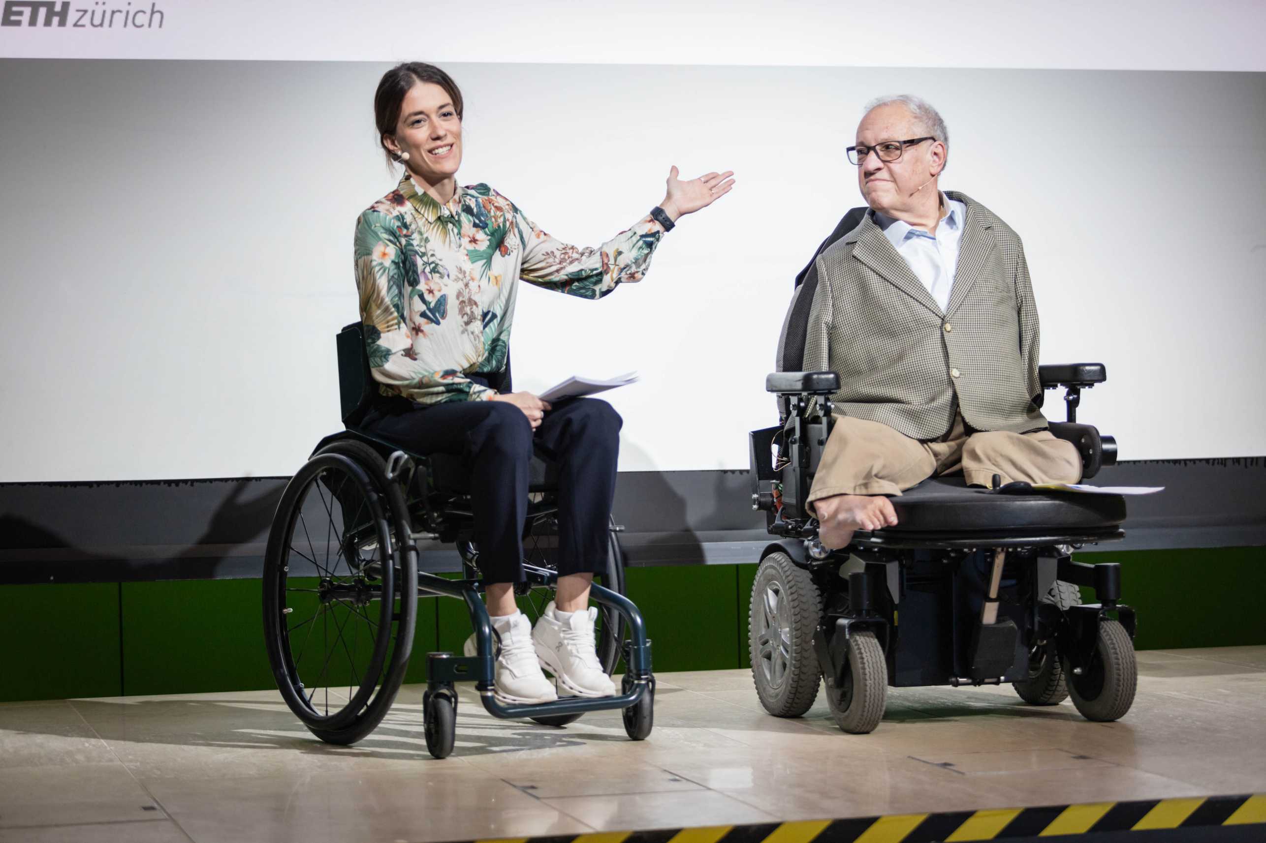 Enlarged view:  Rubina Meixgerand Christian Lohr on stage. Both are sitting in wheelchairs