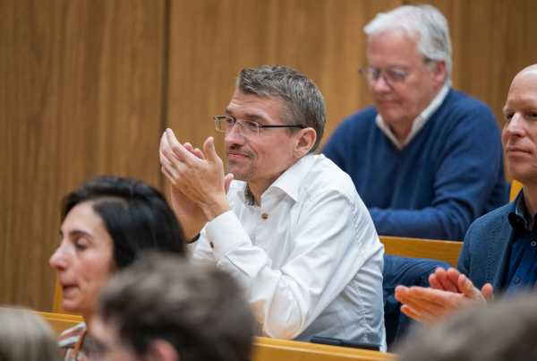 Enlarged view: Person in the audience applauds the speaker