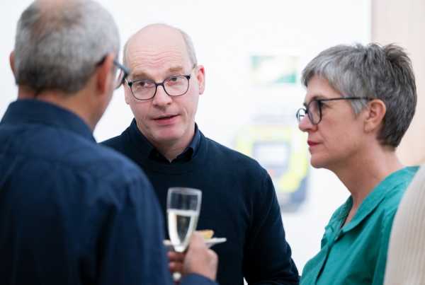 Three people discuss during an aperitif