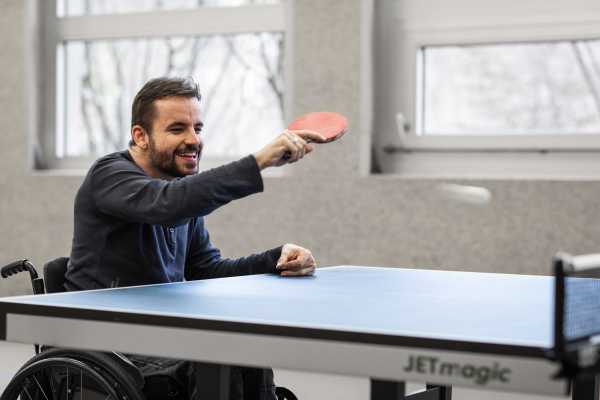 Philippe Amann plays table tennis sitting in a wheelchair