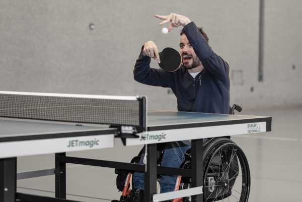 Philippe Amann plays table tennis sitting in a wheelchair