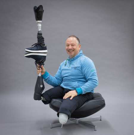 Enlarged view: Rüdiger Böhm with two prosthetic legs fools around and balances one prosthetic leg on the other