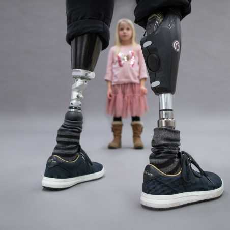 Enlarged view: Rüdiger Böhm with two prosthetic legs is facing a little girl, who is watching the man with attention.