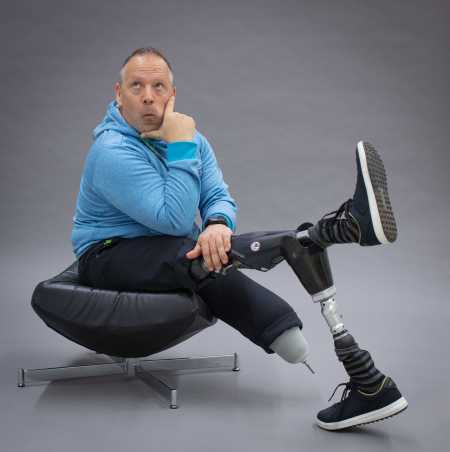 Enlarged view: Rüdiger Böhm with two prosthetic legs sits in a relaxed position and fool around