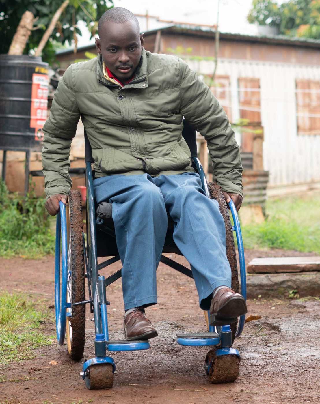 Enlarged view: man with wheelchair drives through muddy terrain