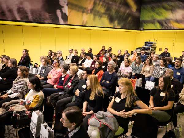 Enlarged view: Audience in the auditorium with yellow walls during the RESC Symposium
