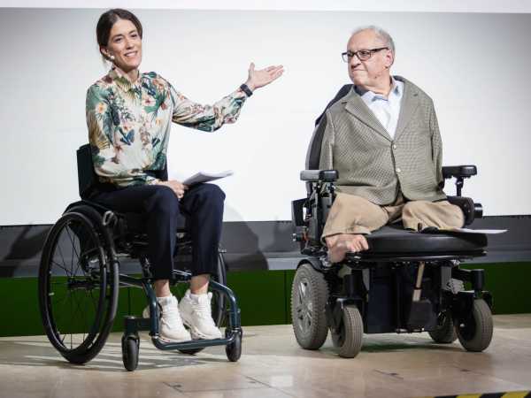 Enlarged view: @RESC, Stefan Schneller Rubina Meixgerand Christian Lohr on stage. Both are sitting in wheelchairs