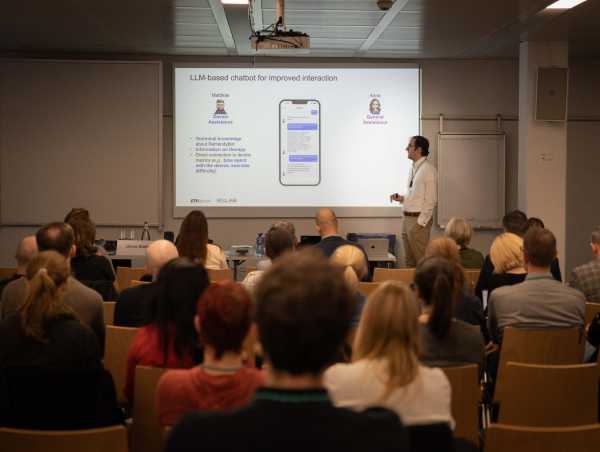 Olivier Lambercy speaking in front of a presentation that shows smartphone app for rehabilitation